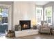 Cozy fireplace featuring a white brick surround, elegant decor, and a relaxing ambiance at 8915 W Quarto Pl, Littleton, CO 80128
