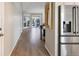 Clean hallway featuring light wood flooring, leading to a bright living area at 8915 W Quarto Pl, Littleton, CO 80128