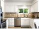 Bright kitchen features stainless steel appliances and light granite countertops at 8915 W Quarto Pl, Littleton, CO 80128