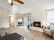 Bright living room with a white brick fireplace, modern furniture, and light wood floors at 8915 W Quarto Pl, Littleton, CO 80128