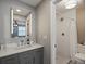 Updated main bathroom with modern vanity, large mirror, and a walk-in shower at 8915 W Quarto Pl, Littleton, CO 80128