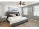 Primary bedroom featuring a ceiling fan, white brick wall and light-filled windows at 8915 W Quarto Pl, Littleton, CO 80128