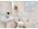 Clean and modern bathroom with pedestal sink and toilet at 7932 E 49Th Pl, Denver, CO 80238