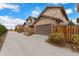 Two-car garage with driveway and wooden fence at 7932 E 49Th Pl, Denver, CO 80238