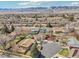 Expansive aerial view of a suburban neighborhood nestled against a backdrop of scenic mountains on a sunny day at 2085 S Deframe St, Lakewood, CO 80228