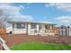 Manicured backyard with a small deck, luscious green lawn, and small storage sheds at 2085 S Deframe St, Lakewood, CO 80228
