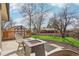 Backyard featuring a stone patio with firepit, Adirondack chairs, and lush green lawn at 2085 S Deframe St, Lakewood, CO 80228