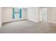 Spacious basement with neutral carpet, blue curtains, and access to other rooms at 2085 S Deframe St, Lakewood, CO 80228