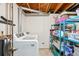 Unfinished basement with a washer, dryer, storage, and utilities at 2085 S Deframe St, Lakewood, CO 80228
