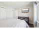 Bedroom featuring tv, dresser, and closet with white doors and a window at 2085 S Deframe St, Lakewood, CO 80228