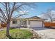 Charming single-story home boasts a well-manicured lawn, attached two-car garage, and welcoming front entrance at 2085 S Deframe St, Lakewood, CO 80228
