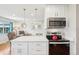 Open kitchen with modern appliances, quartz countertops, and adjacent living area at 2085 S Deframe St, Lakewood, CO 80228