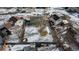 Aerial view of a spacious backyard featuring mature trees and a wooden fence, partially covered in snow at 1109 Ash Ct, Fort Lupton, CO 80621