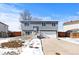 Gray two-story house with white garage door, snowy yard, and wooden fence at 1109 Ash Ct, Fort Lupton, CO 80621