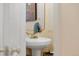 Bathroom features pedestal sink with gold fixtures and decorative mirror at 18489 E Columbia Cir, Aurora, CO 80013