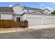 Home exterior features a two-car garage, fenced yard and tidy landscaping at 18489 E Columbia Cir, Aurora, CO 80013