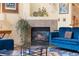 Cozy living room area featuring a fireplace, plush blue seating, and tasteful decor at 18489 E Columbia Cir, Aurora, CO 80013