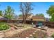 Expansive backyard featuring raised garden beds, a fire pit seating area, and mature trees for outdoor enjoyment at 2390 N Springwood Ct, Lafayette, CO 80026