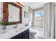 Well-lit bathroom featuring a modern vanity, decorative mirror, and shower-tub combination at 2390 N Springwood Ct, Lafayette, CO 80026