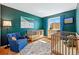 Bright Bedroom with two cribs, a blue accent wall, and hardwood floors at 2390 N Springwood Ct, Lafayette, CO 80026