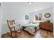 Bright bedroom featuring hardwood floors, a rocking chair and a window with backyard views at 2390 N Springwood Ct, Lafayette, CO 80026