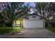 Charming single-story home with a two-car garage, green lawn, and mature trees at sunset at 2390 N Springwood Ct, Lafayette, CO 80026