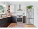 Modern kitchen featuring stainless steel appliances, wooden countertops, and stylish black cabinets at 2390 N Springwood Ct, Lafayette, CO 80026