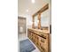 Bathroom with rustic wood vanity, double sinks, and decorative mirrors at 3970 Longwood Ave, Boulder, CO 80305