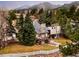 Two story home with stone chimney, balcony, and surrounded by beautiful trees at 3970 Longwood Ave, Boulder, CO 80305