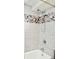 Shower with a stone pebble accent, rainfall shower head, and gray porcelain tile at 3970 Longwood Ave, Boulder, CO 80305