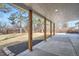 View of a spacious covered patio with wooden support beams and concrete flooring overlooking a fenced backyard at 6635 S Sherman St, Centennial, CO 80121