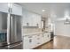 Well-lit kitchen features stainless appliances, granite countertops, white cabinets and hardwood floors at 6635 S Sherman St, Centennial, CO 80121