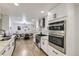 Bright kitchen with stainless steel appliances, granite counters, and hardwood flooring leads to the dining area at 6635 S Sherman St, Centennial, CO 80121