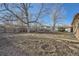 Large backyard with mature trees, storage shed, and fire pit area, perfect for entertaining at 2925 S Ingalls Way, Denver, CO 80227
