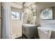 Well-lit bathroom with a gray vanity, tile shower, and modern fixtures at 2925 S Ingalls Way, Denver, CO 80227