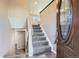 Inviting entryway with gray carpeted stairs leading to the upper level and beautiful wood-look tiled flooring at 2925 S Ingalls Way, Denver, CO 80227