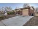 Attractive home featuring a brick exterior, attached garage, and a concrete driveway at 2925 S Ingalls Way, Denver, CO 80227
