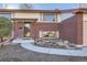 Charming brick home featuring a well-kept front yard, a covered porch, and neutral shutters at 2925 S Ingalls Way, Denver, CO 80227