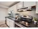 Close-up of kitchen featuring stainless steel oven, sink, and gray subway tile backsplash at 2925 S Ingalls Way, Denver, CO 80227