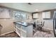 Open-concept kitchen and dining area with an island, stainless steel appliances, and a modern table set at 2925 S Ingalls Way, Denver, CO 80227