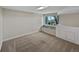 Finished basement area with plush carpet, a window seat, and built-in storage cabinets at 2418 W 82Nd Pl # D, Westminster, CO 80031