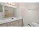 Bathroom with large mirror over white vanity with toilet and bath/shower visible in the reflection at 395 Raspberry Ln, Monument, CO 80132