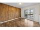 This bedroom features wood paneling, hardwood floors, and access to the deck via sliding glass doors at 395 Raspberry Ln, Monument, CO 80132