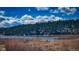 Scenic view of a serene lake surrounded by lush trees and dramatic cloudy blue skies at 395 Raspberry Ln, Monument, CO 80132