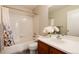 Bright bathroom featuring a shower-tub combo, tile surround, and a single sink vanity at 8129 Locust Dr, Littleton, CO 80125