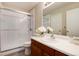 Clean bathroom featuring glass enclosed shower, wood vanity, and bright white countertop at 8129 Locust Dr, Littleton, CO 80125