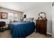 Inviting bedroom with blue comforter, dresser and chair perfect for guests or Gathering at 8129 Locust Dr, Littleton, CO 80125