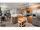 Traditional kitchen with stainless steel appliances and light wood cabinets is adjacent to the dining and living area at 8129 Locust Dr, Littleton, CO 80125