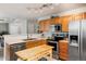 Traditional kitchen with stainless steel appliances, light wood cabinets, and a view to the living area at 8129 Locust Dr, Littleton, CO 80125