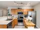 Traditional kitchen with stainless steel appliances, light wood cabinets, and a view to the living area at 8129 Locust Dr, Littleton, CO 80125